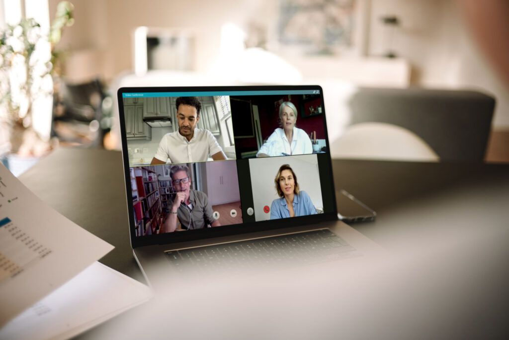 Business people having online meeting. Group of men and woman having a video conference over a laptop.